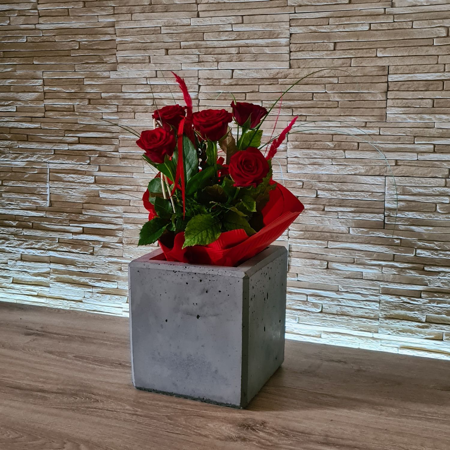 Donica z betonu architektonicznego w salonie, z kwiatami